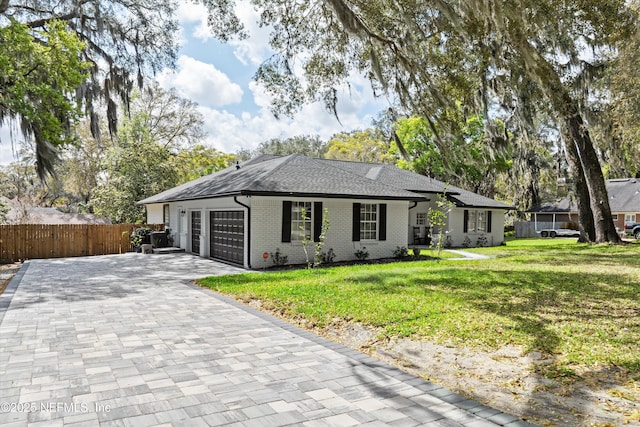 ranch-style house featuring brick siding, a front yard, fence, a garage, and driveway