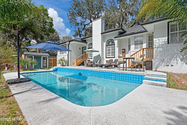 outdoor pool with a patio and an outdoor structure