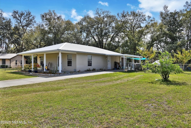 view of front facade with a front yard, metal roof, fence, and driveway