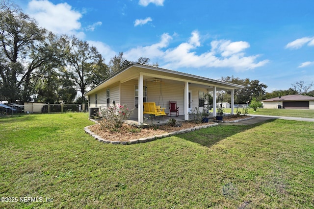 view of property exterior with a porch, a yard, and fence