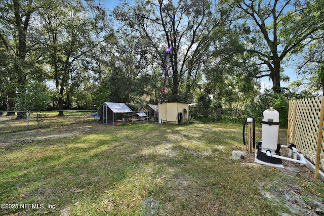 view of yard with an outdoor structure, fence, and exterior structure