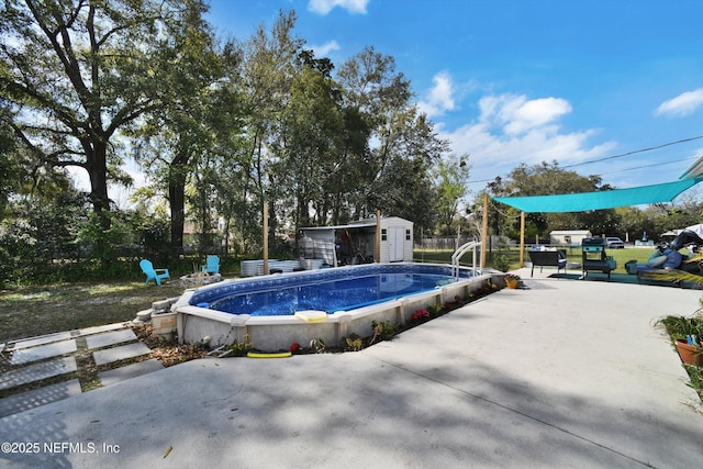 view of pool with a storage shed, a patio area, fence, and an outbuilding