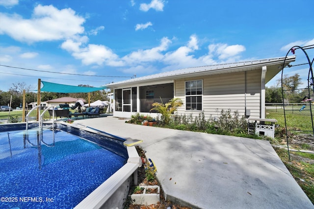 view of swimming pool with a sunroom, fence, and a patio