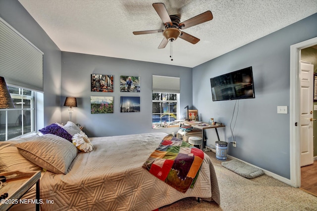 bedroom featuring a textured ceiling, carpet floors, a ceiling fan, and baseboards