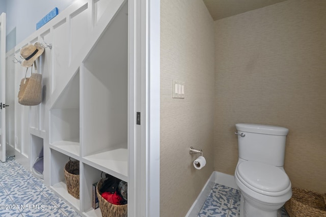 bathroom with toilet and baseboards