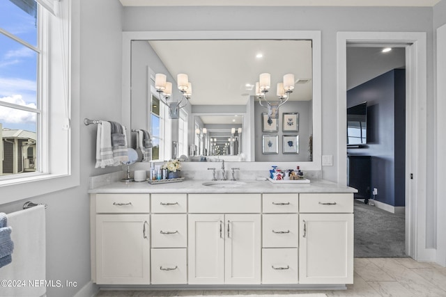 bathroom with marble finish floor, baseboards, and vanity