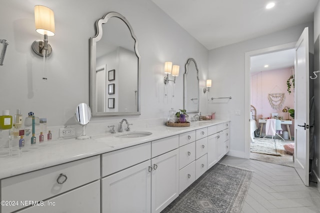 bathroom with double vanity, ensuite bath, and a sink