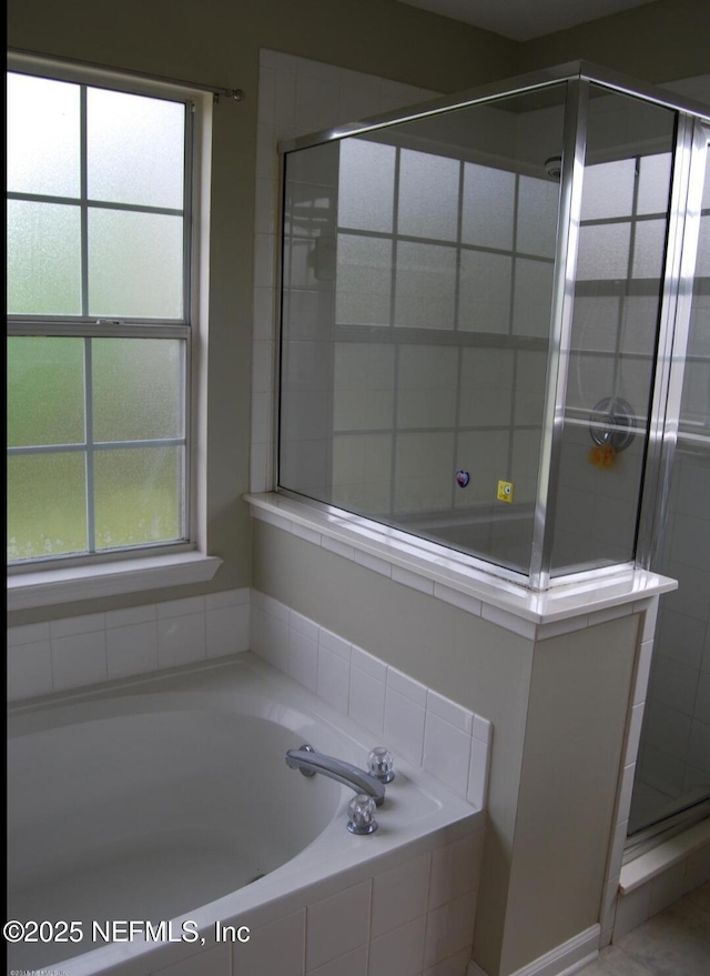 full bath featuring a stall shower, a wealth of natural light, and a bath