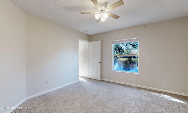 empty room with a ceiling fan, a textured ceiling, visible vents, and carpet flooring