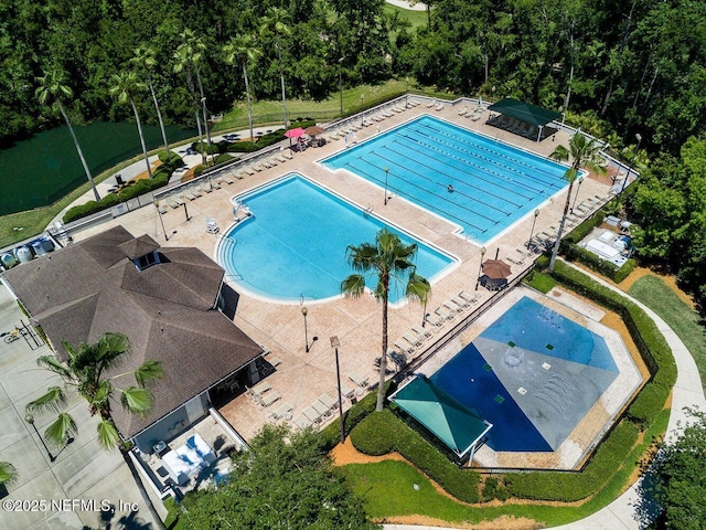 community pool featuring fence and a patio