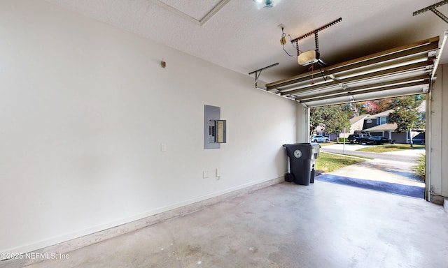 garage featuring electric panel, baseboards, and a garage door opener