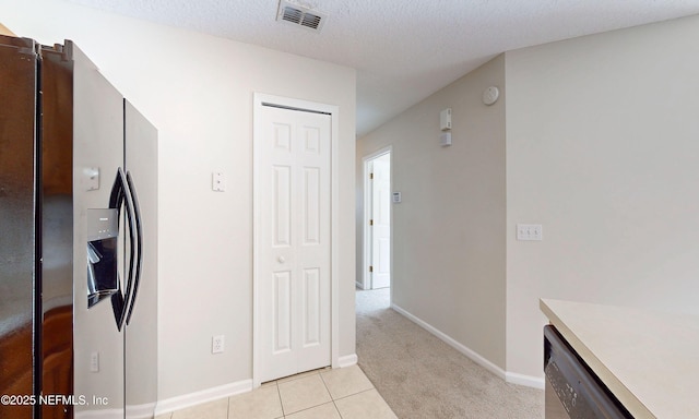 kitchen featuring baseboards, visible vents, stainless steel appliances, a textured ceiling, and light tile patterned flooring