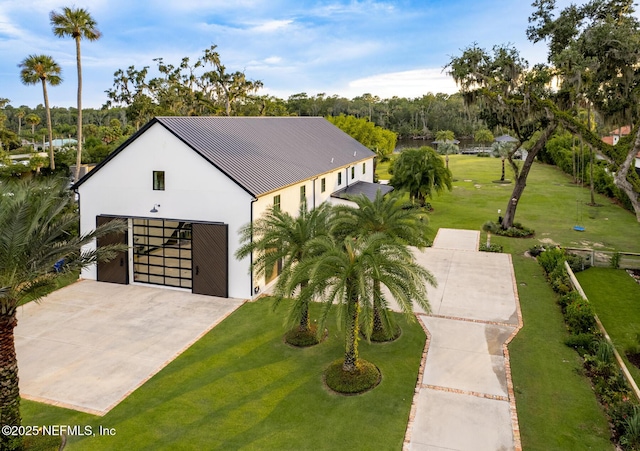 view of front of home with driveway, a front lawn, an outdoor structure, and stucco siding