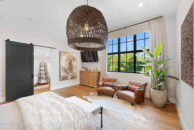 living area with a barn door, recessed lighting, wood finished floors, and baseboards