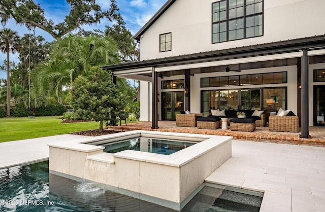 back of property featuring ceiling fan, an in ground hot tub, a patio area, and an outdoor living space