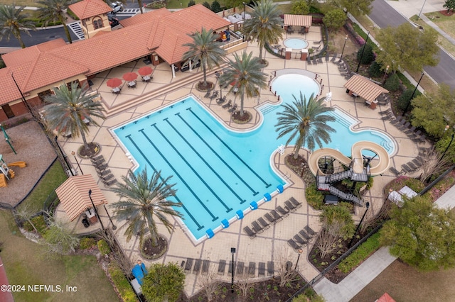 community pool with a patio and fence