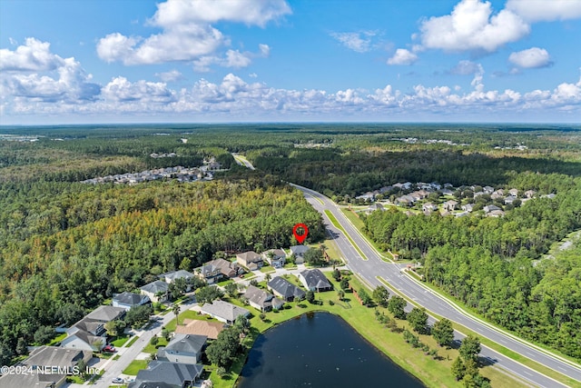 birds eye view of property with a water view, a residential view, and a view of trees