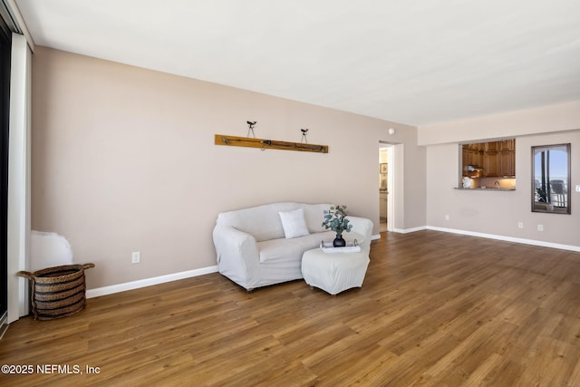 sitting room with baseboards and wood finished floors