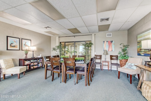 carpeted dining room with visible vents and a drop ceiling