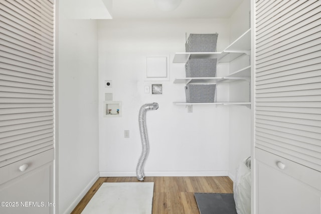 clothes washing area featuring wood finished floors, baseboards, hookup for an electric dryer, hookup for a washing machine, and laundry area