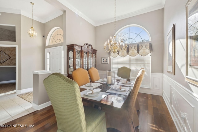 dining area featuring crown molding, a notable chandelier, and wood finished floors