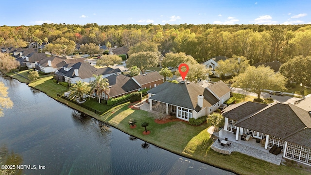 birds eye view of property featuring a residential view, a water view, and a forest view