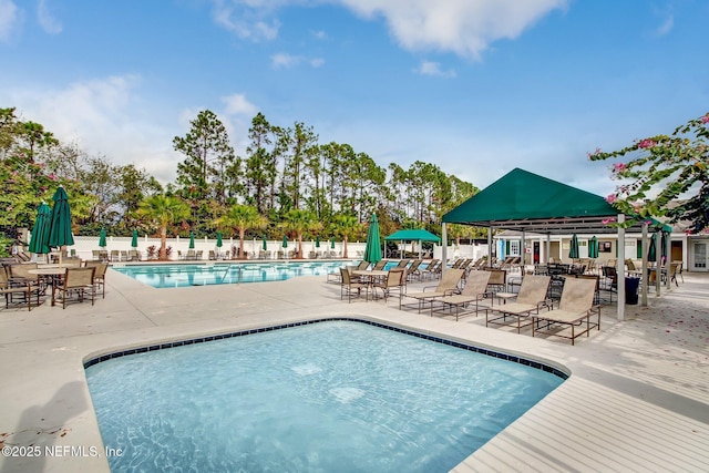 community pool featuring fence and a patio