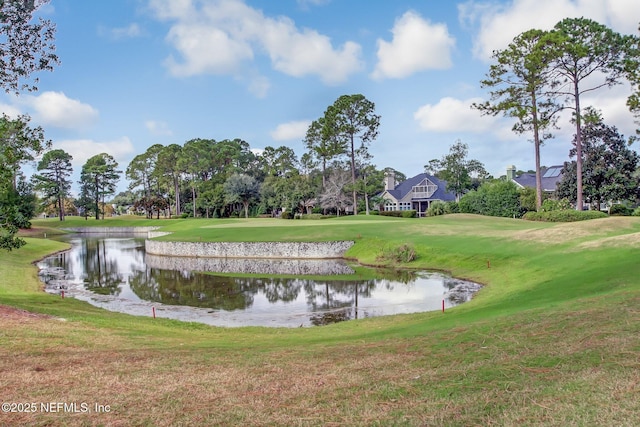 surrounding community with a water view, golf course view, and a lawn