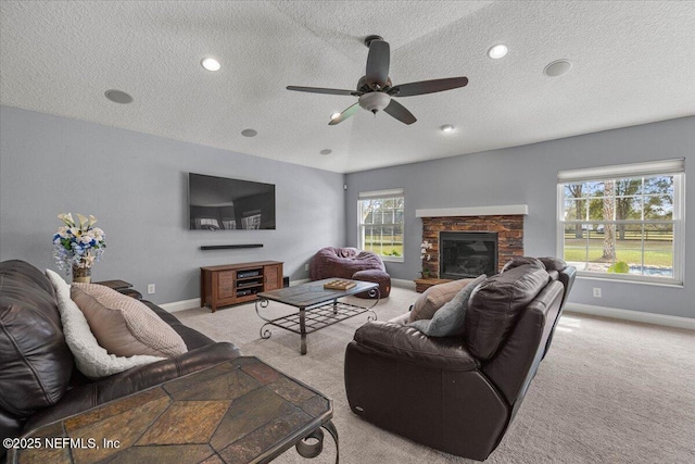 living area with light carpet, baseboards, a textured ceiling, and a stone fireplace