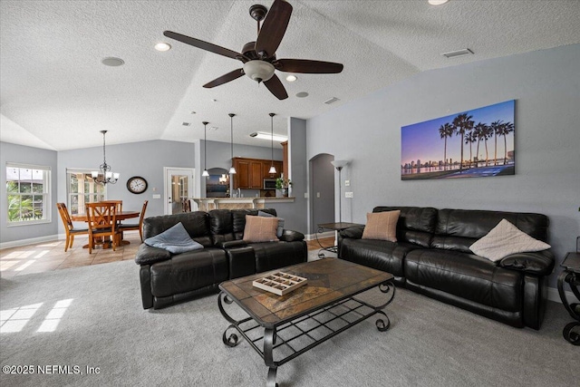 living area featuring arched walkways, vaulted ceiling, a textured ceiling, and light colored carpet