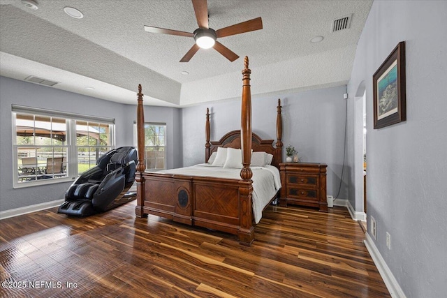 bedroom featuring a ceiling fan, wood finished floors, visible vents, and baseboards