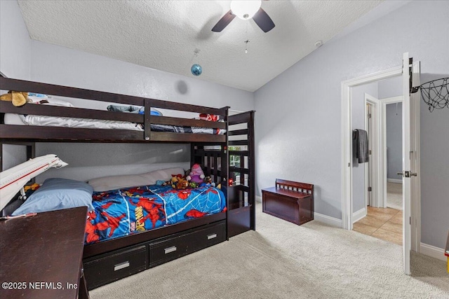 bedroom featuring a textured ceiling, carpet flooring, a ceiling fan, baseboards, and vaulted ceiling