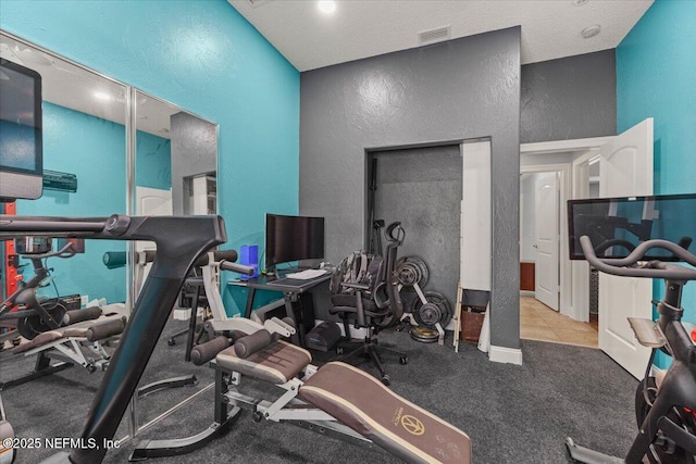 exercise area with visible vents and a textured wall