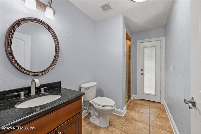 bathroom featuring baseboards, visible vents, toilet, tile patterned floors, and a textured ceiling