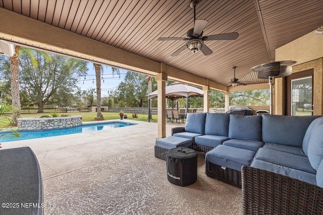 view of patio featuring ceiling fan, a fenced backyard, an outdoor pool, and an outdoor hangout area