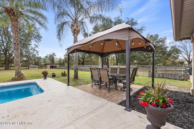 view of pool with a patio area, a fenced backyard, a lawn, and a gazebo