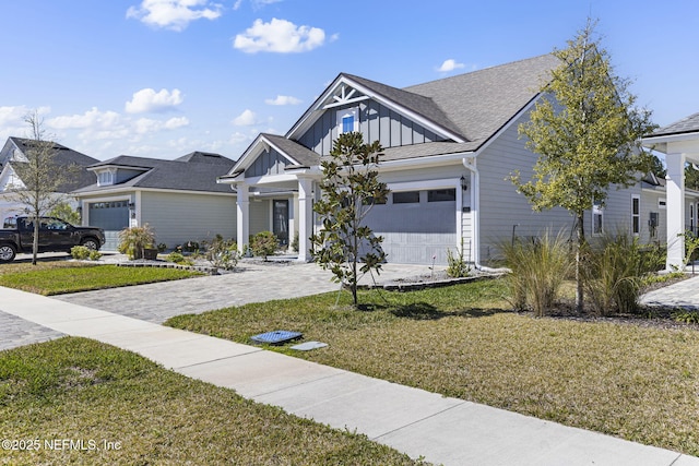 view of front of house featuring an attached garage, decorative driveway, and board and batten siding