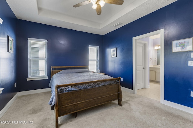 bedroom featuring a tray ceiling, carpet flooring, visible vents, and baseboards