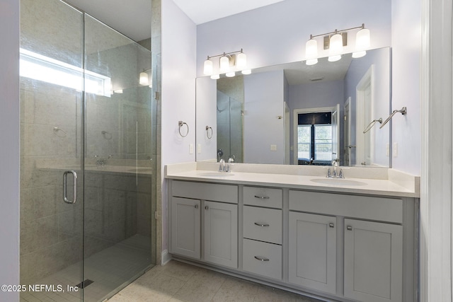 bathroom featuring double vanity, a sink, and a shower stall