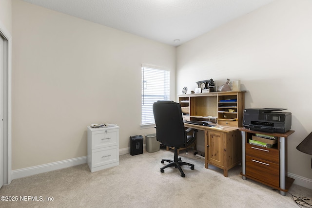 office space featuring baseboards and light colored carpet