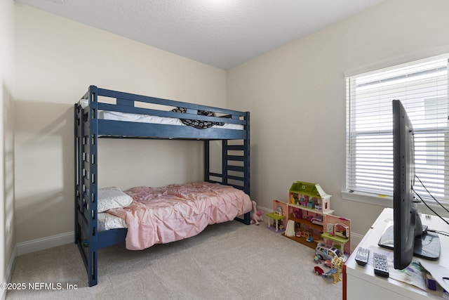 carpeted bedroom with a textured ceiling and baseboards