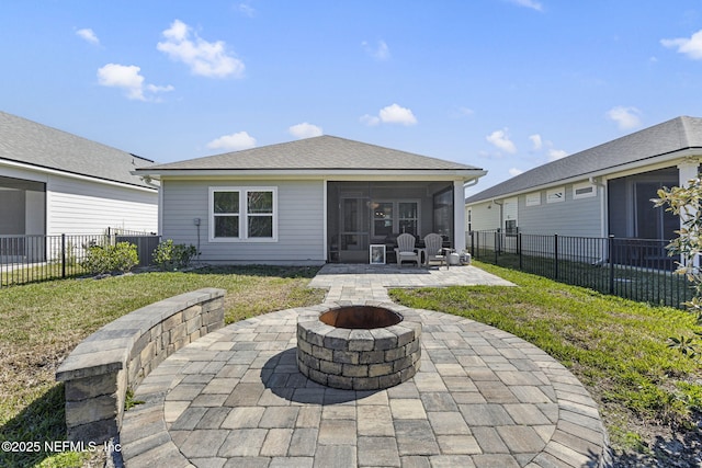 rear view of house featuring an outdoor fire pit, a lawn, a patio, a sunroom, and a fenced backyard