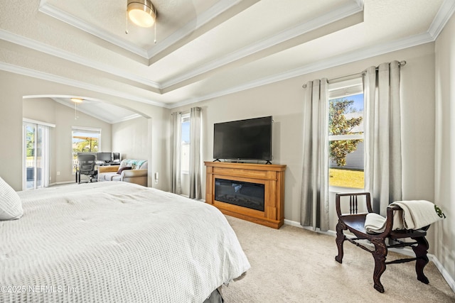 bedroom with light carpet, a tray ceiling, arched walkways, and ornamental molding