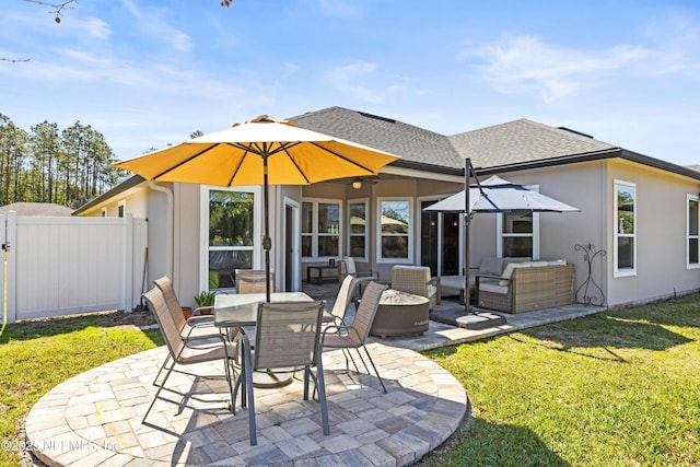 back of property featuring roof with shingles, a patio, a lawn, fence, and an outdoor living space