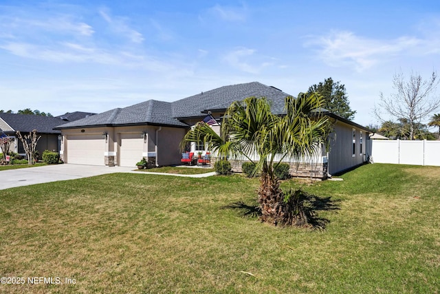 view of front of house featuring a shingled roof, concrete driveway, an attached garage, fence, and a front lawn