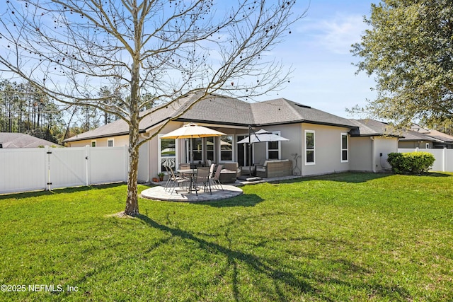 rear view of house with a lawn, a patio, a fenced backyard, a gate, and stucco siding