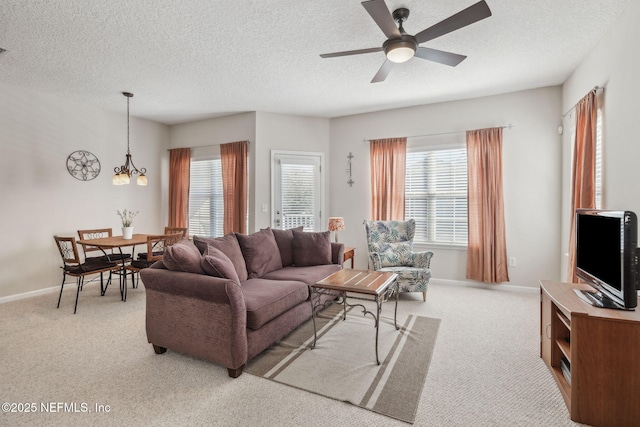 7157 Deerfoot Point Cir Unit 10-2, Jacksonville, FL 32256 - living room featuring light carpet, baseboards, a textured ceiling, and ceiling fan with notable chandelier