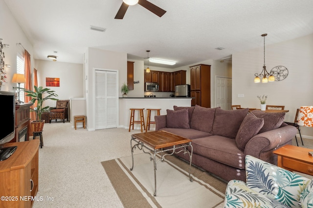 7157 Deerfoot Point Cir Unit 10-2, Jacksonville, FL 32256 - carpeted living area featuring ceiling fan with notable chandelier, visible vents, and baseboards