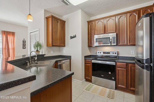 7157 Deerfoot Point Cir Unit 10-2, Jacksonville, FL 32256 - kitchen with stainless steel appliances, dark countertops, visible vents, a sink, and a peninsula