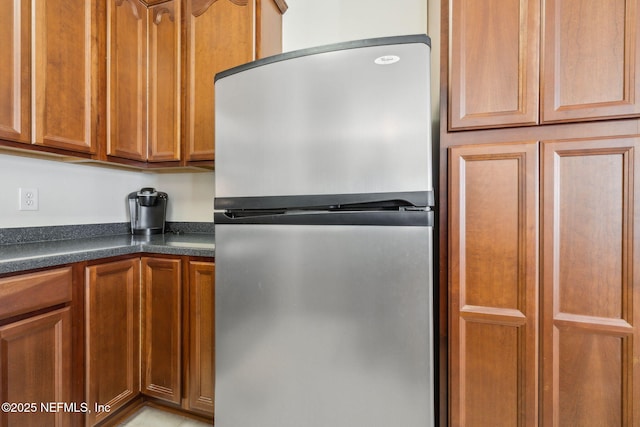 7157 Deerfoot Point Cir Unit 10-2, Jacksonville, FL 32256 - kitchen featuring dark countertops, brown cabinets, and freestanding refrigerator